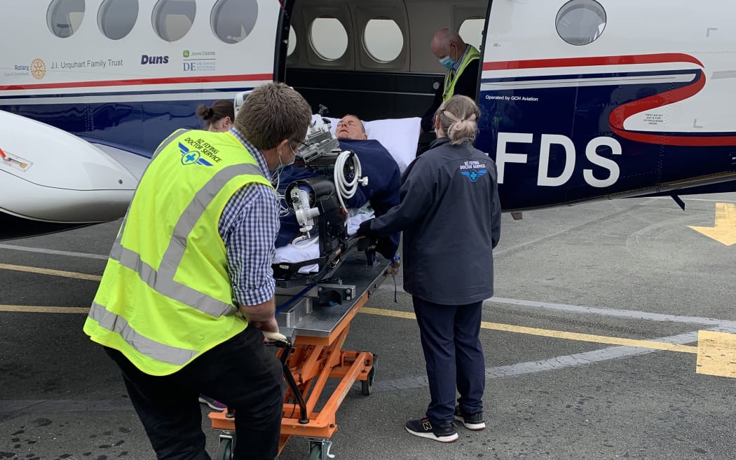 Mark Sullivan being loaded into an NZ Flying Doctors plane in 2022 after surviving a plane crash near Murchison.