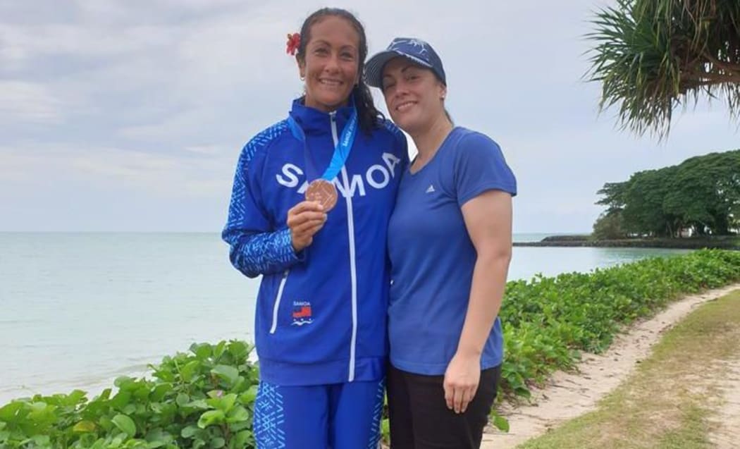Anne Cairns with Pacific Games medal from Va'a race alongside supportive sister Bridget Cairns at the 2019 Pacific Games