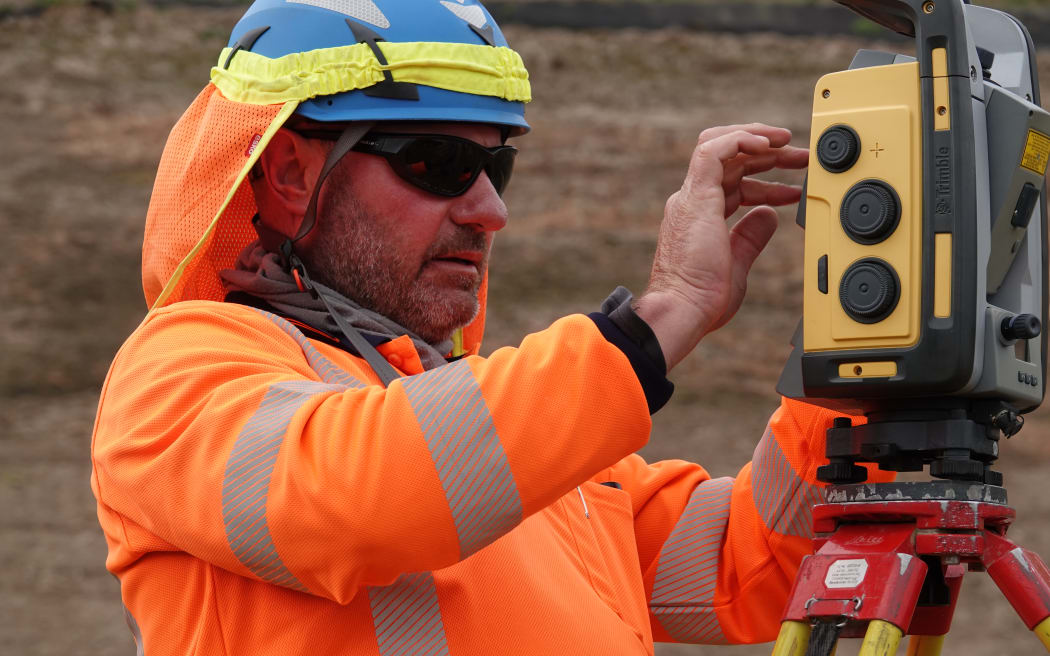 Surveyor Chris Bester checks everything is in the right place on one of the new road's under-construction bridges.