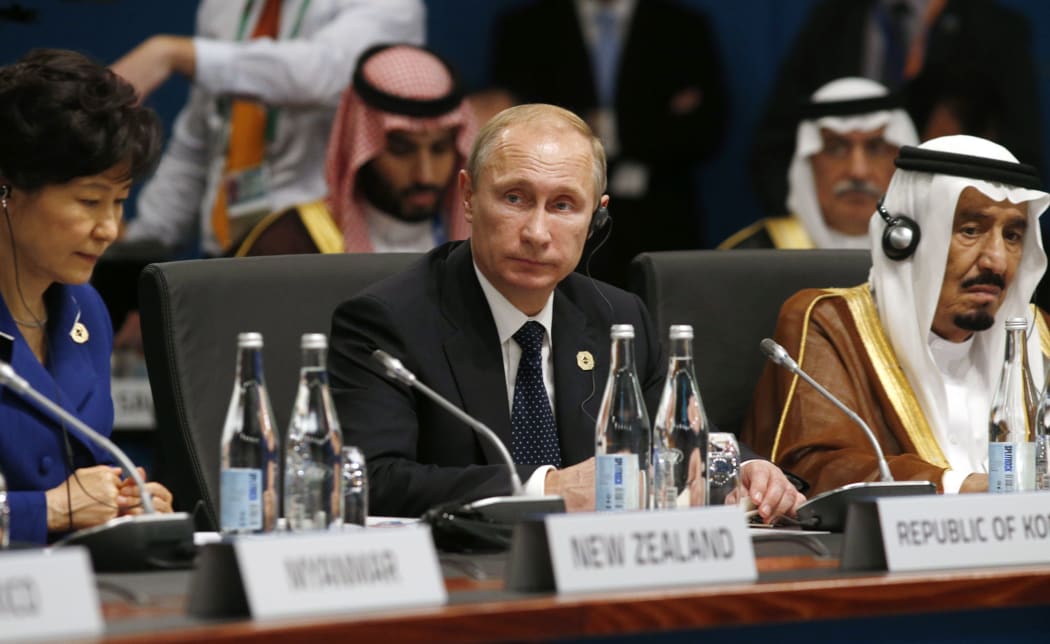 Vladimir Putin (C) looks up as South Korean President Park Geun-hye (L) and Saudi Arabia Crown Prince Salman bin Abdulaziz (R) listen at the start of the plenary session at the G20 Summit.