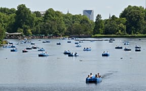 Sun-seekers ride pedalos and row boats on the Serpentine in Hyde Park, central London on July 17, 2021, as forecasters expect the mercury to hit 31C in England, with even higher temperatures forecast for Sunday.