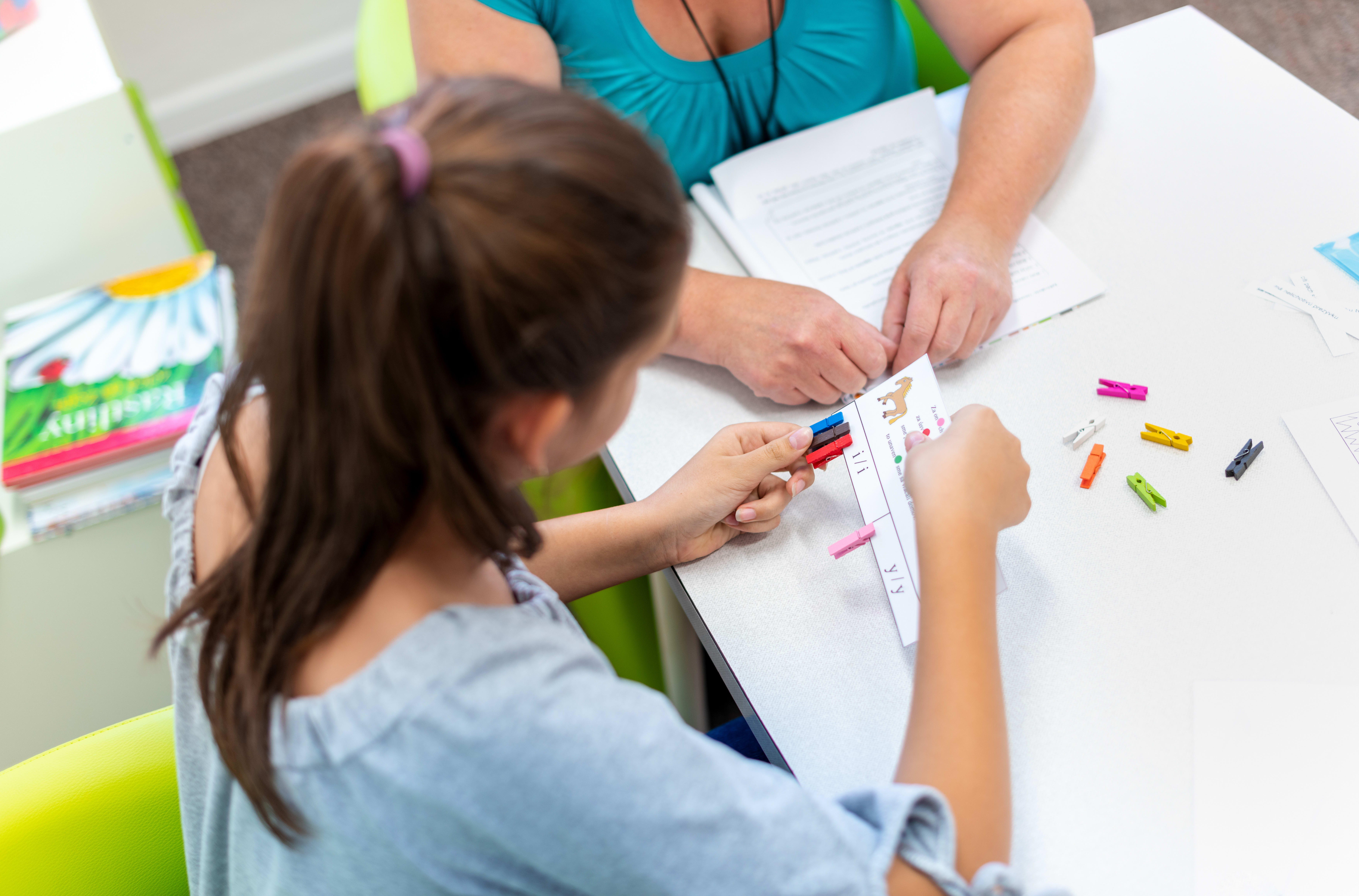 Teacher working with a teenage girl with learning difficulties.