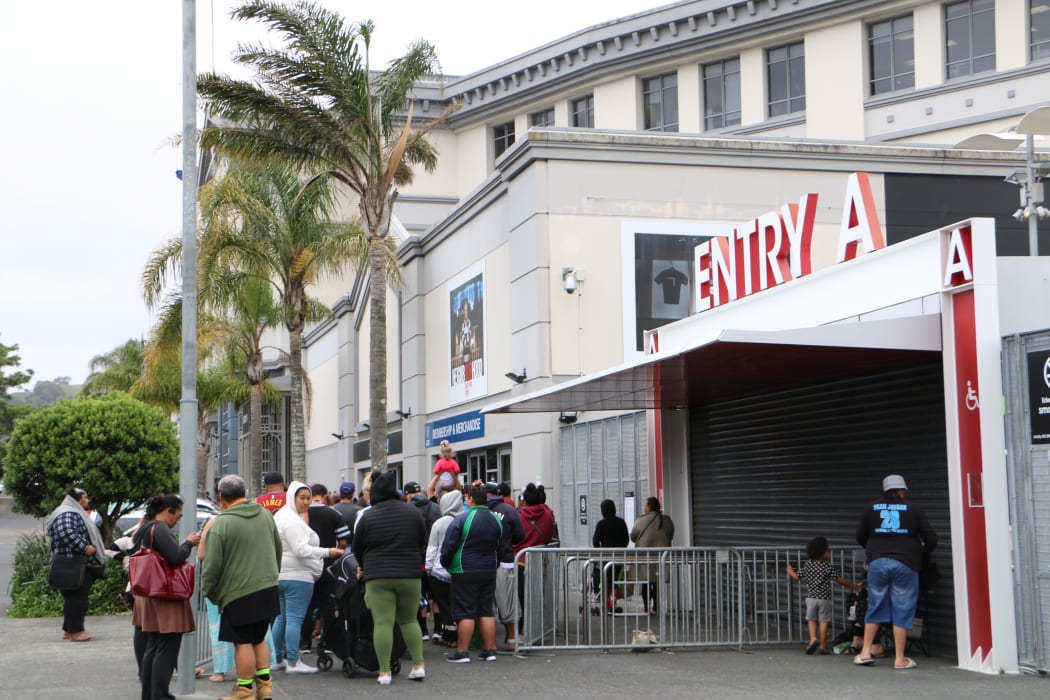 People line up outside Eden Park to collect food and Christmas gifts from Auckland City Mission.