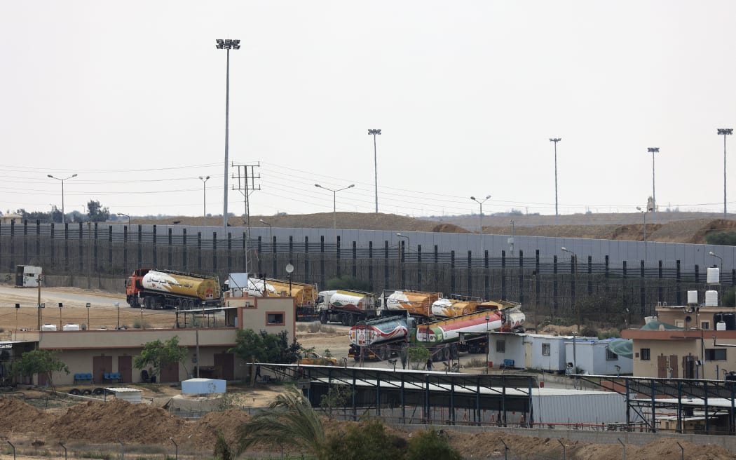 Trucks leave Gaza's Rafah border crossing with Egypt during an Israeli airstrike on October 10, 2023. Gaza's border crossing with Egypt, its only one that bypasses Israel, was hit by an Israeli air strike on October 10, 2023 for the second time in 24 hours, witnesses and a rights group said. Witnesses said the strike hit the no-man's land between the Egyptian and Palestinian gates, damaging the hall on the Palestinian side.