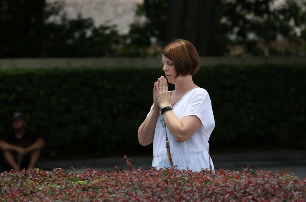 A woman prays at a site about a block from the Pulse nightclub in the aftermath of a mass shooting in Orlando, Florida, on June 12, 2016.