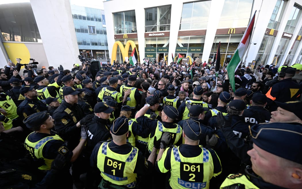 Pro-Palestinian demonstrators face police outside the Malmo Arena venue ahead of the final of the 68th Eurovision Song Contest (ESC) 2024 on 11 May, 2024 in Malmo, Sweden.