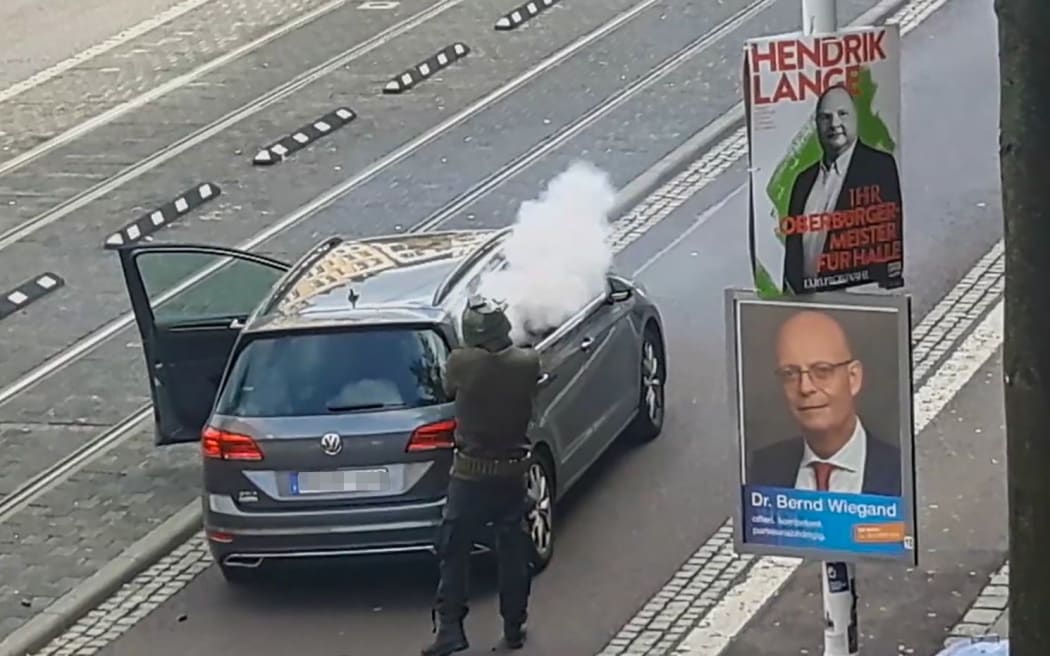 In this screenshot taken from a video by ATV-Studio Halle, a man shoots in the streets of Halle an der Saale, eastern Germany, on October 9, 2019.