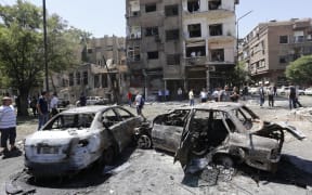 Charred vehicles at the site of a suicide bomb attack in the Syrian capital Damascus.
