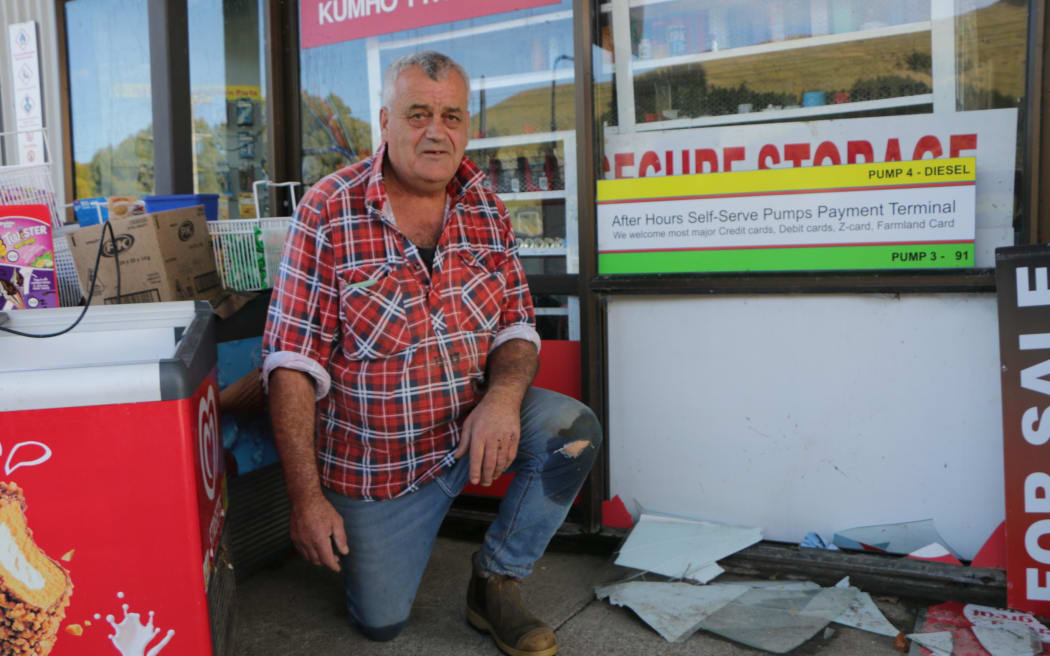 Andrew Davis shows the windows which were blown out by floodwater on Thursday.