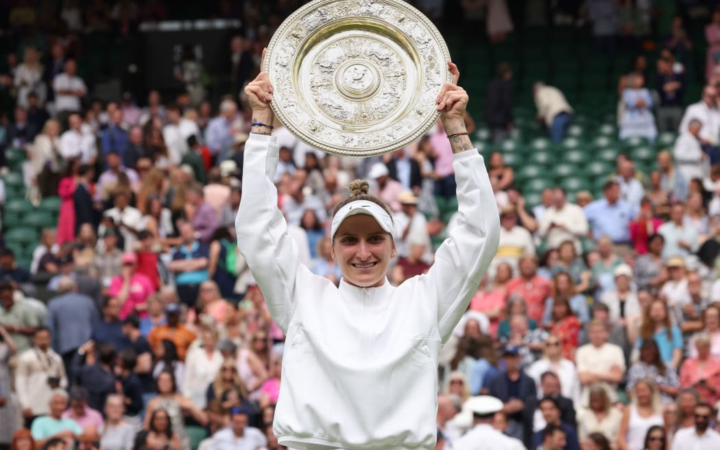 Marketa Vondrousova (CZE) lifts the Ladies Singles Plate after defeating Ons Jabeur in the 2023 Wimbledon Ladies Singles final.