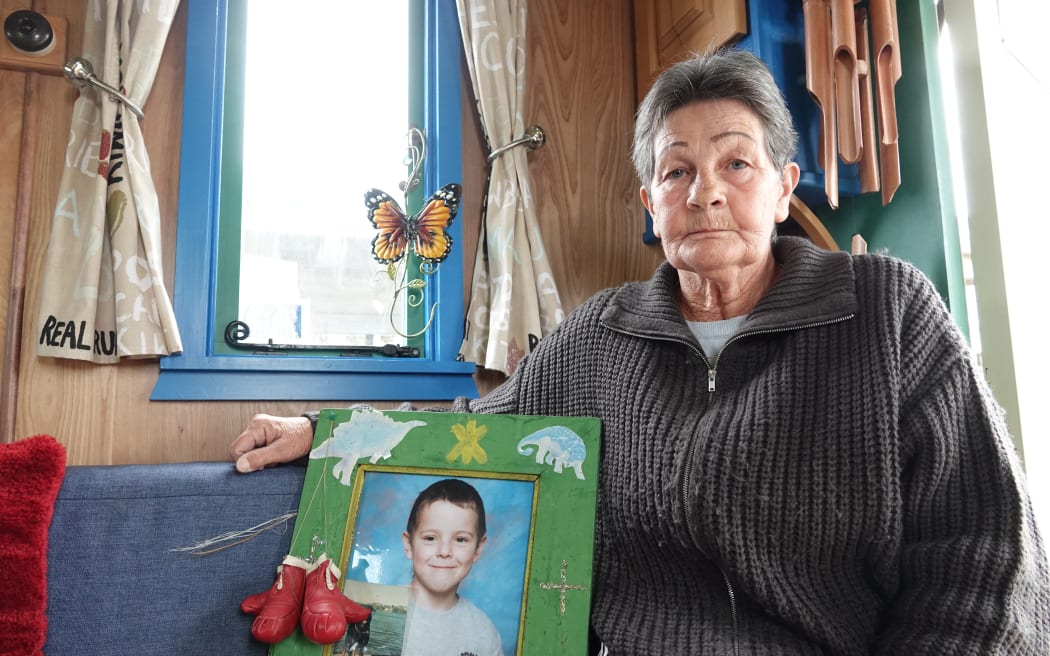 Robyn Dandy sits inside her travelling wagon with a photo of her grandson, Kahn Petch.
