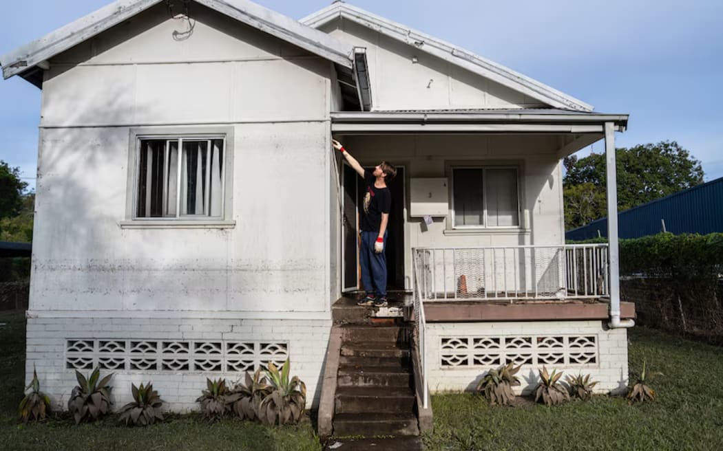 Jake points out how high the floodwaters reached at the house.