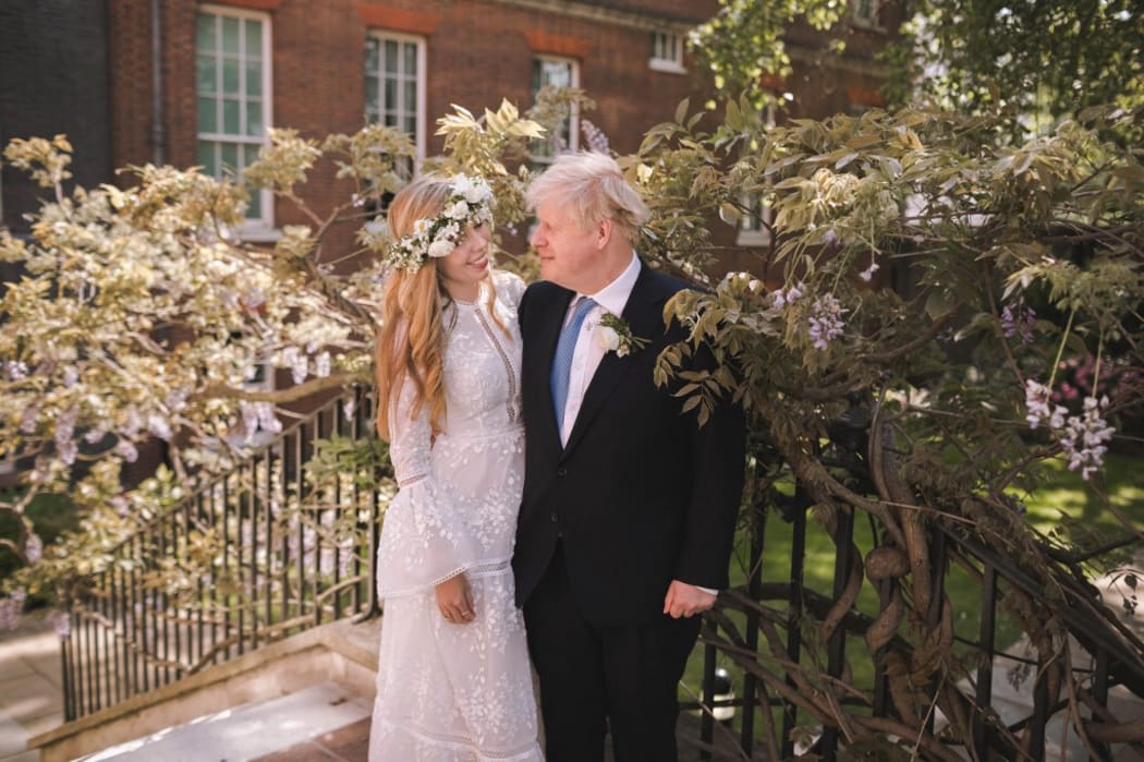 A handout picture released by 10 Downing Street on May 30, 2021 shows Britain's Prime Minister Boris Johnson and his wife Carrie Johnson in the garden of 10 Downing Street, London after their wedding on Saturday, May 29, 2021.