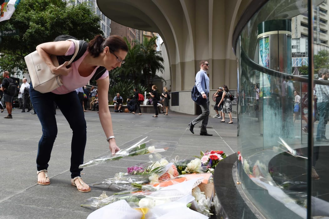 Members of the public lay flowers near the Lindt chocolate cafe.