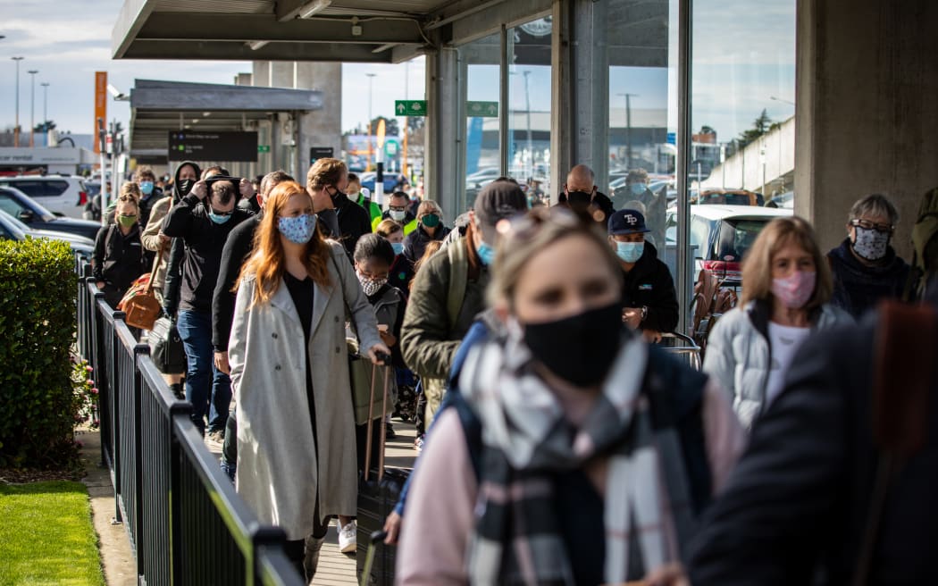 Passengers head back into the Christchurch Airport terminal after an evacuation due to a bomb scare.