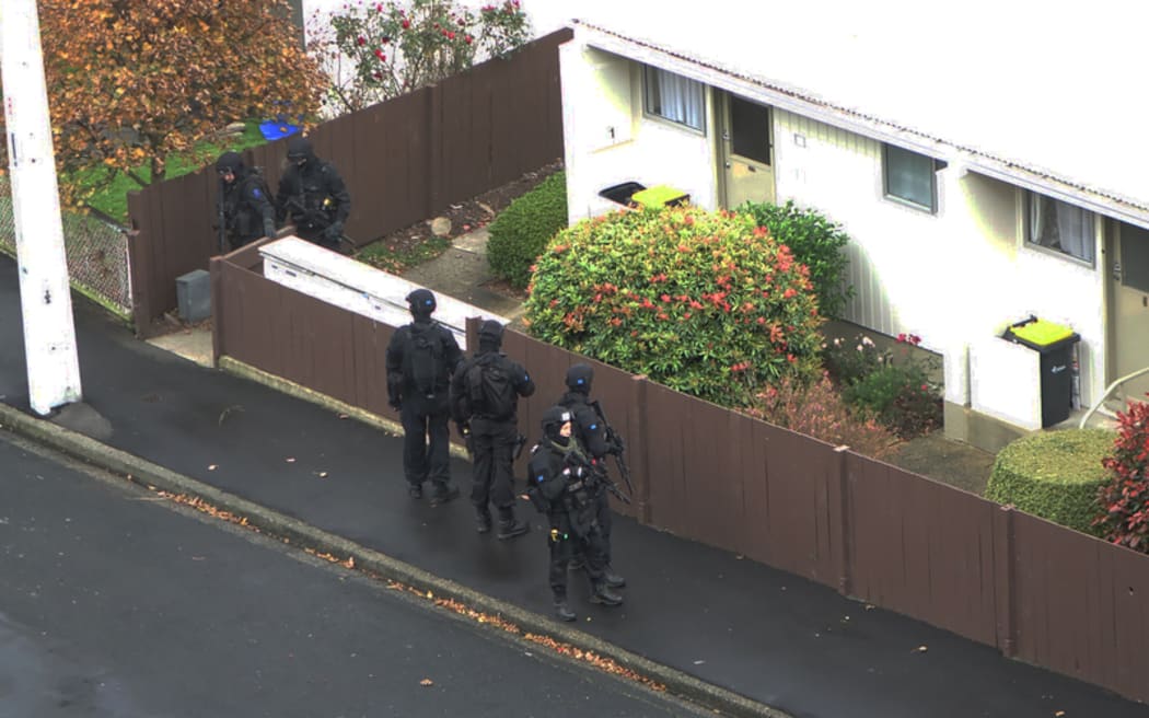Armed offenders squad members outside a Dunedin house.