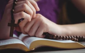Woman praying with her bible.