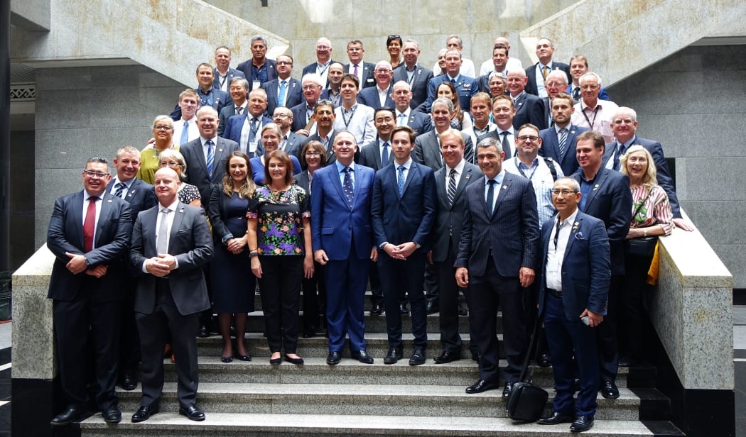 Prime Minister John Key in Beijing on a staircase surrounded by his business and trade delegation of about forty people