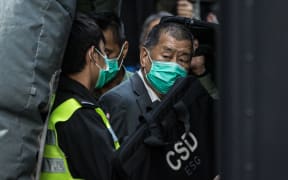 Media tycoon Jimmy Lai (R) is escorted into a Hong Kong Correctional Services van outside the Court of Final Appeal in Hong Kong on February 1, 2021, after being ordered to remain in jail while judges consider his fresh bail application, the first major legal challenge to a sweeping national security law Beijing imposed on the city last year. (Photo by AFP)