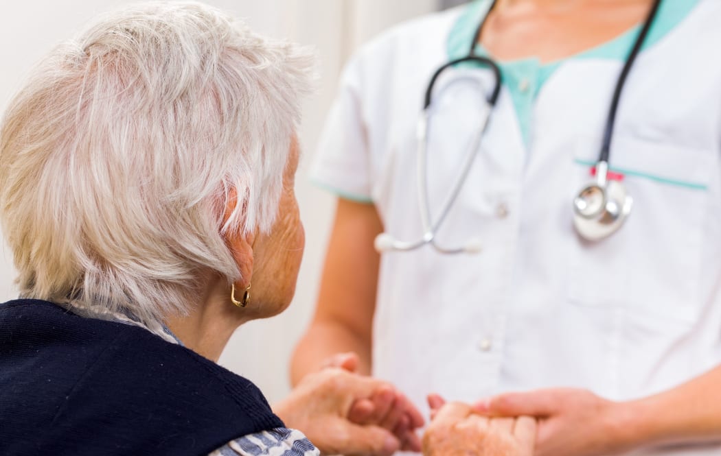 Young doctor giving helping hands for elderly woman