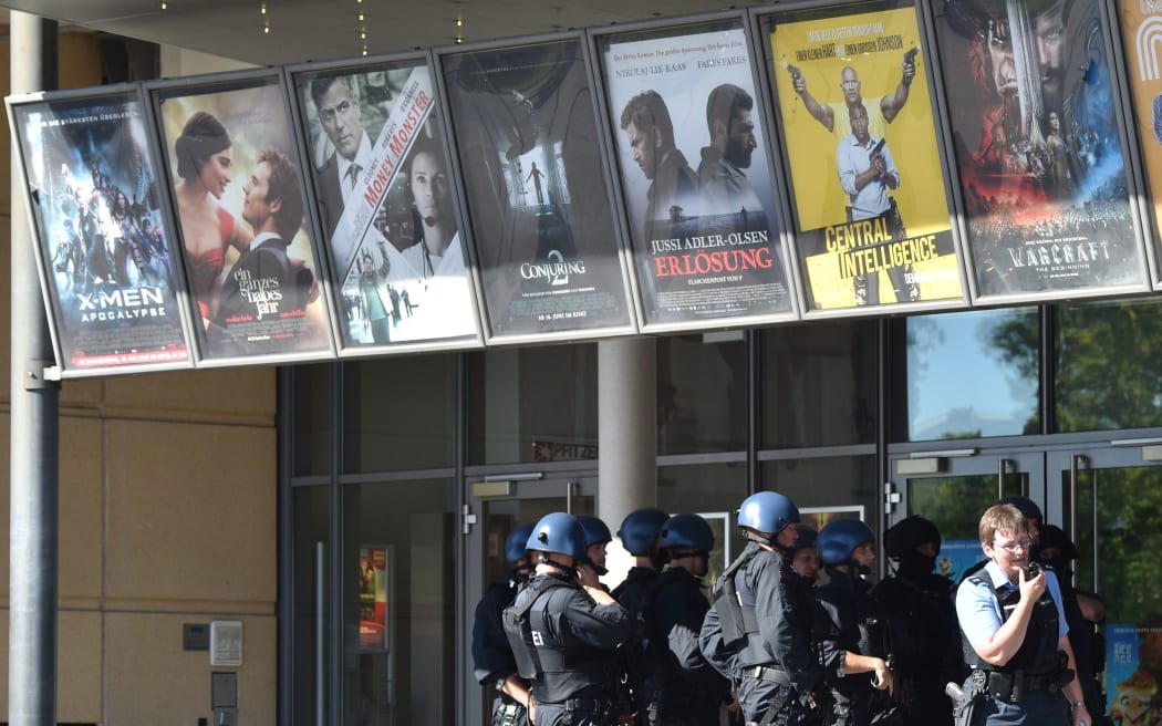 Police forces stand in front of a cinema where an armed man barricaded himself in Viernheim, southern Germany.