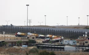 Trucks leave Gaza's Rafah border crossing with Egypt during an Israeli airstrike on October 10, 2023. Gaza's border crossing with Egypt, its only one that bypasses Israel, was hit by an Israeli air strike on October 10, 2023 for the second time in 24 hours, witnesses and a rights group said. Witnesses said the strike hit the no-man's land between the Egyptian and Palestinian gates, damaging the hall on the Palestinian side.