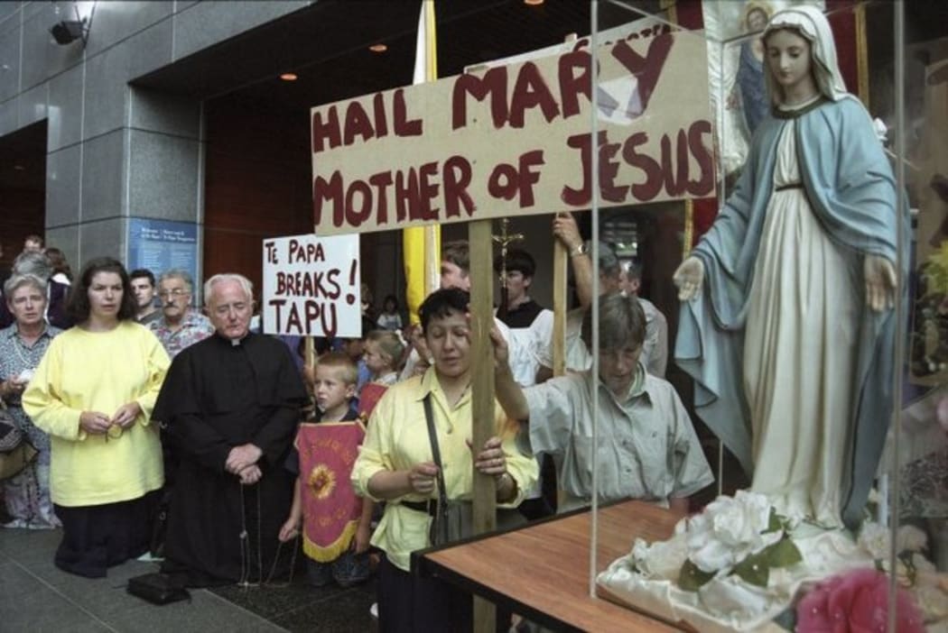 People outside Te Papa Museum protest in 1998 about Tania Kovats' 'Virgin in a condom' exhibit in Wellington, after the Museum refused to remove it.