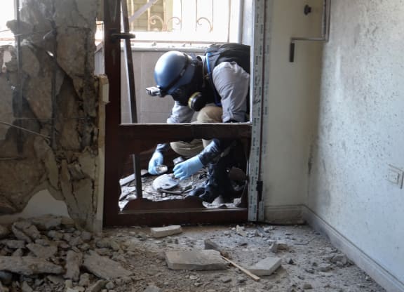 A UN arms expert collects samples in August at a site in Ghouta in Damascus after a suspected chemical weapons strike near the capital.