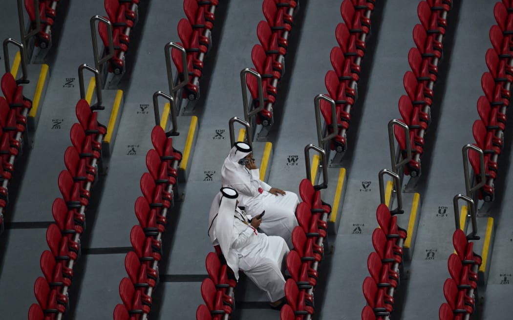 Fans sit among empty seats as they attend the Qatar 2022 World Cup Group A football match between the Netherlands and Qatar at the Al-Bayt Stadium in Al Khor, north of Doha on 29 November, 2022.