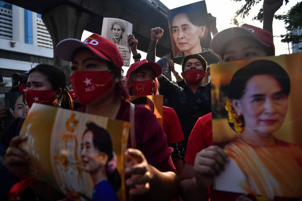 Myanmar migrants hold up portraits of Aung San Suu Kyi as they demonstrae  outside the Myanmar embassy in Bangkok on 1 February 2021, over the military coup in Myanmar.