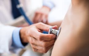 Doctor using stethoscope in examining a small boy