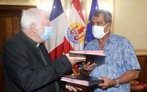 Monsignor Jean-Pierre Cottanceau and president Edouard Fritch swap lease agreements.