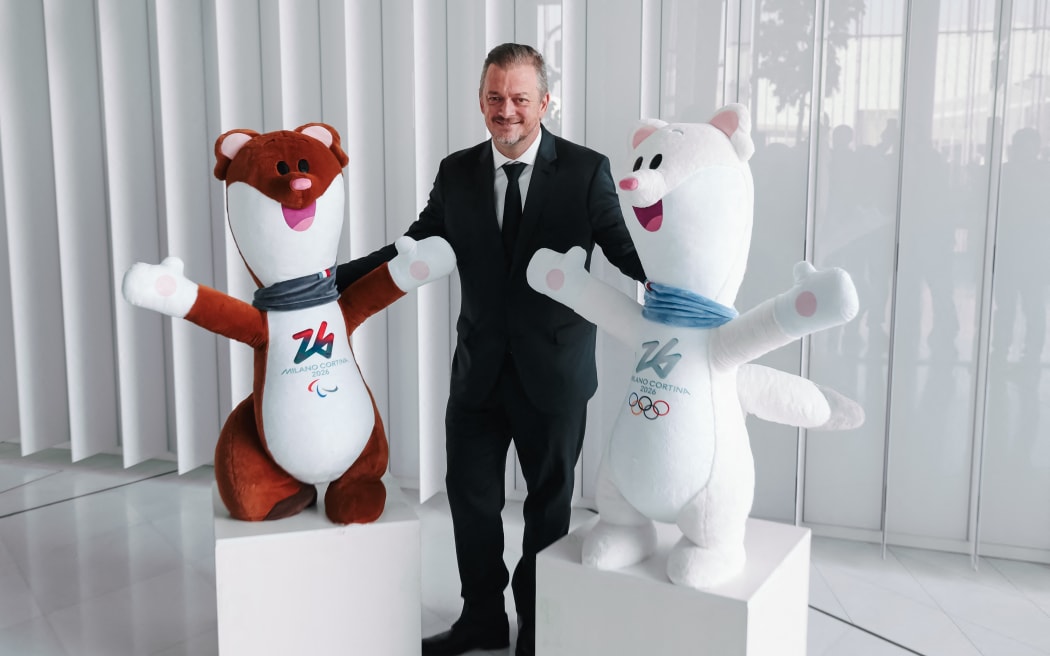Andrew Parsons, President of the International Paralympic Committee, is seen with the mascots Tina and Milo during the press briefing for the Opening Ceremony and on the decision to allow athletes from Russia and Belarus to participate in the Games using their respective countries' flags, anthems, and uniforms during the XIV Winter Paralympic Games Milano Cortina 2026 at the Allianz Tower in Milan, Italy, on February 23, 2026 (Photo by Alessandro Bremec/NurPhoto). (Photo by Alessandro Bremec / NurPhoto via AFP)