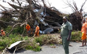 Inmates from Lautoka Correctional Centre are supervised while at work on the Vaileka  town in Rakiraki, Fiji, in the aftermath of Cyclone Winston.