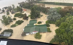 An NH90 helicopter and crew recover people from the rooftops of their homes in Esk Valley, Napier.