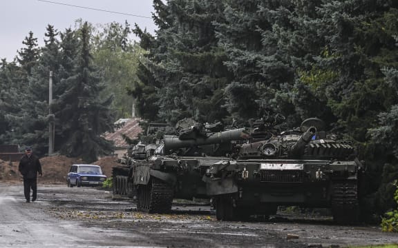 A pedestrian walks past abandoned Russian tanks in Kramatorsk, eastern Ukraine, on 1 October, 2022, amid the Russian invasion of Ukraine.