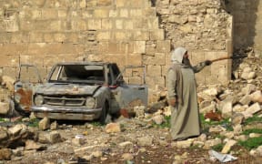 A Syrian man points at the destruction in the market in the government-held old city of Aleppo on December 17. Trapped Syrian civilians and rebels waited desperately Saturday for evacuations to resume from Aleppo.