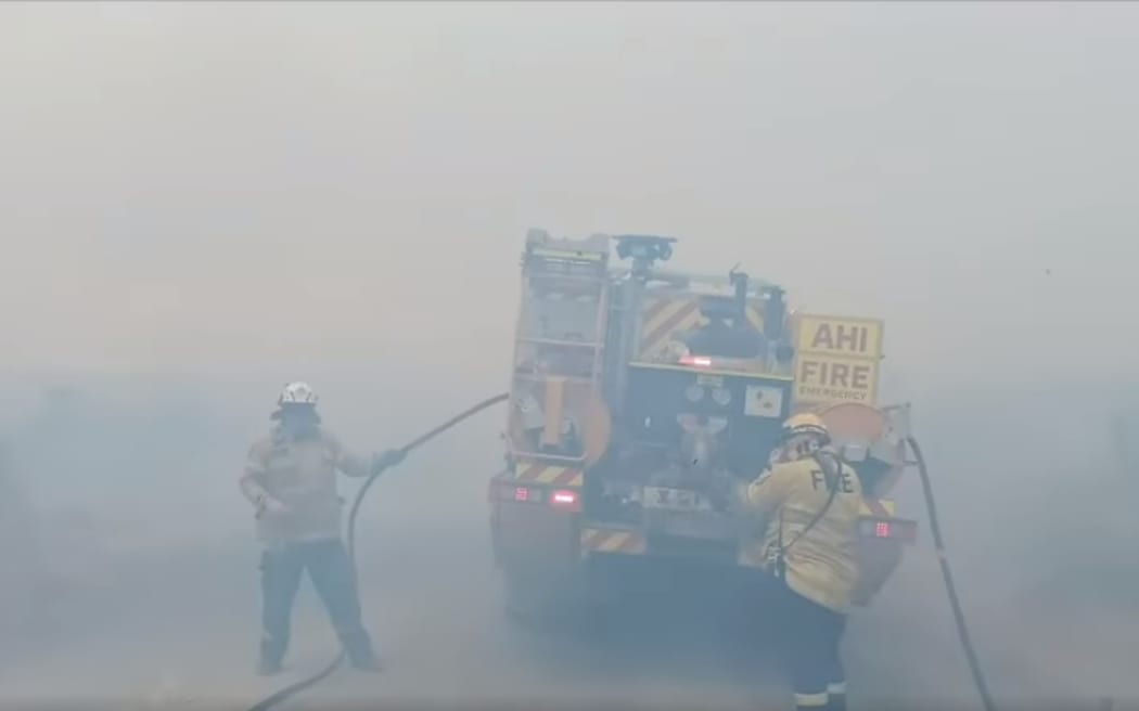Firefighters work to put out the blaze on Matakana Island on 24 December, 2023.