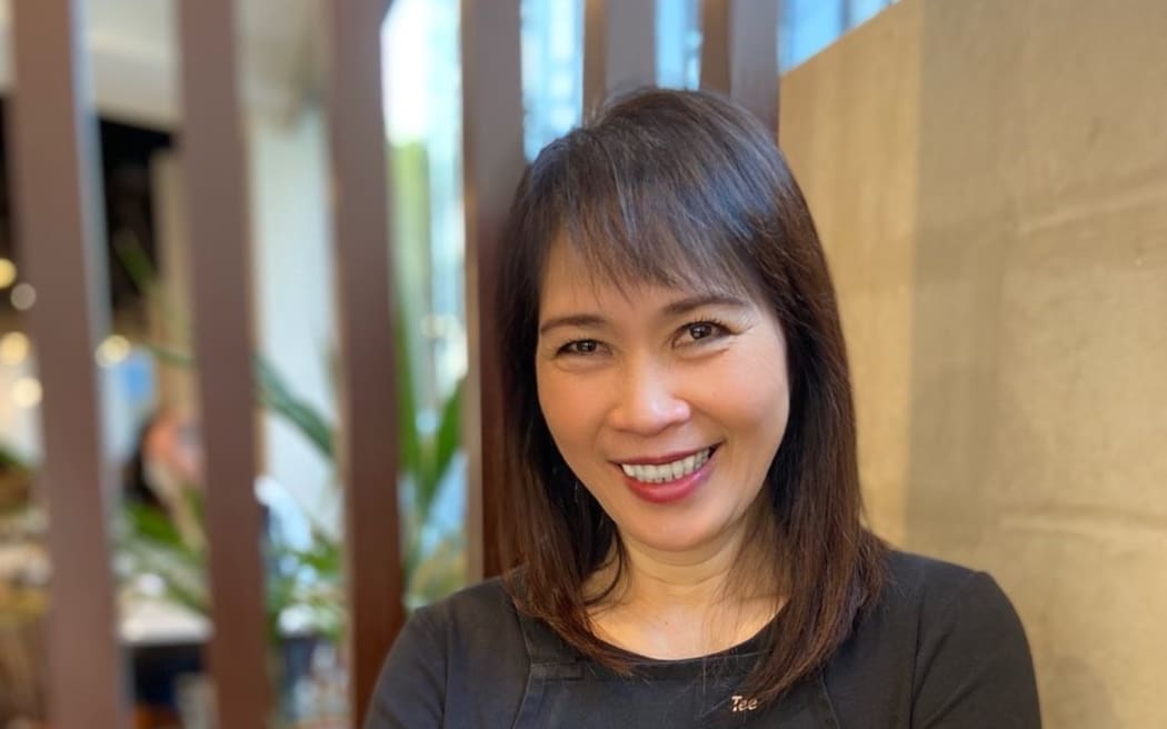 A picture showing Tee Phee, owner at Little Penang, a Malaysian restaurant in Wellington. Phee is standing with a big smile.