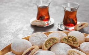 Traditional cookies for Islamic holidays such as Eid, and tea on a table.