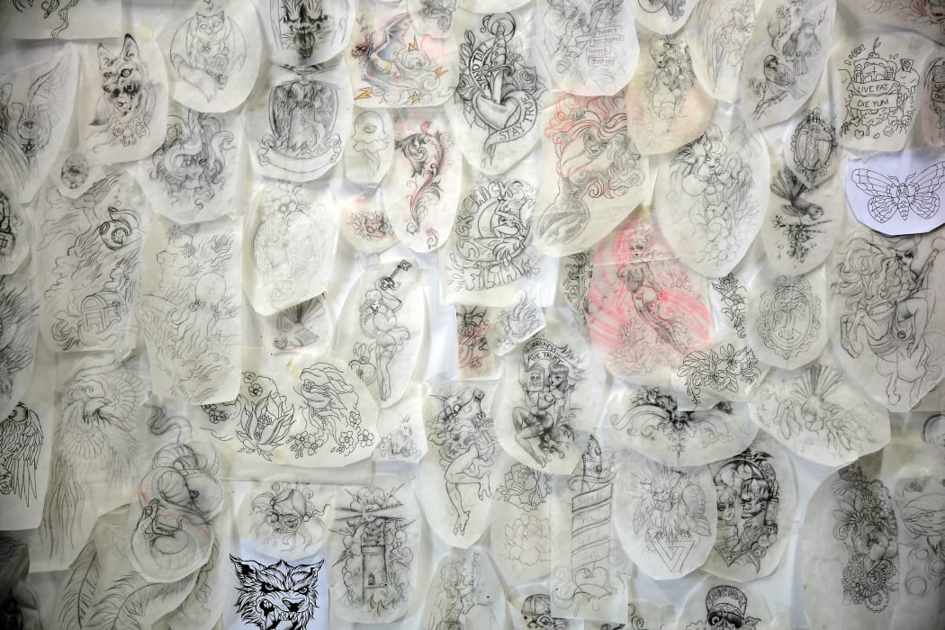A wall of drawings in a tattoo studio.