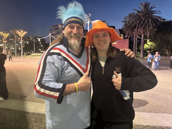 A bearded man and a young man in a bright orange hat.