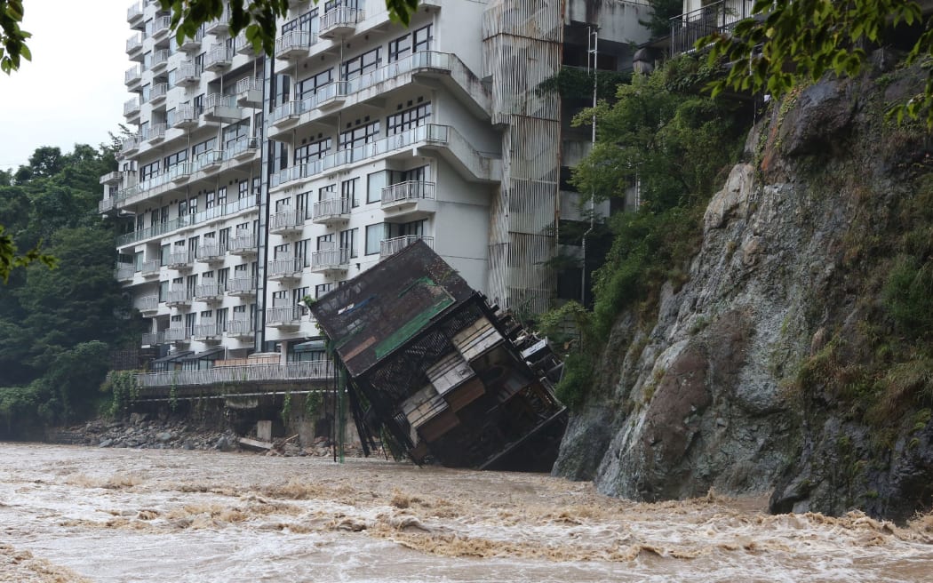 A hotel building falls into the floodwaters at Nikko mountain resort in Tochigi prefecture.