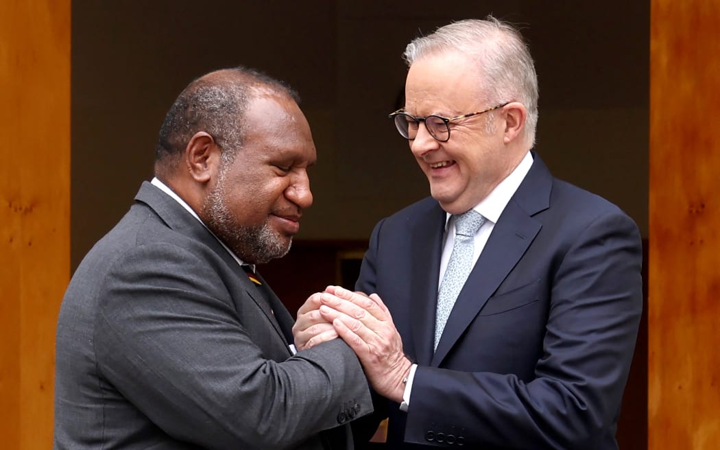 Australia's Prime Minister Anthony Albanese (R) greets Papua New Guinea's Prime Minister James Marape before a signing ceremony at Parliament House in Canberra on October 6, 2025. Australia and Papua New Guinea signed a long-awaited mutual defence treaty, as Canberra seeks to deepen ties with Pacific nations and counter Beijing's rising influence. (Photo by DAVID GRAY / AFP)