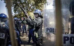 Zimbabwean anti riot police officers stand guard at gate of Rainbow Towers where the election's results were announced.