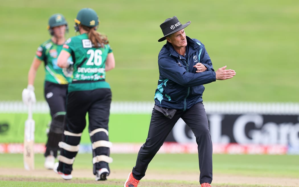 Cricket umpire Billy Bowden signals a boundary.