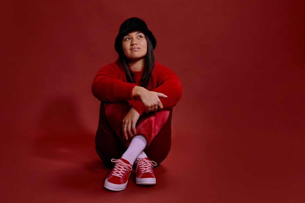 Young Māori woman sitting cross legged
