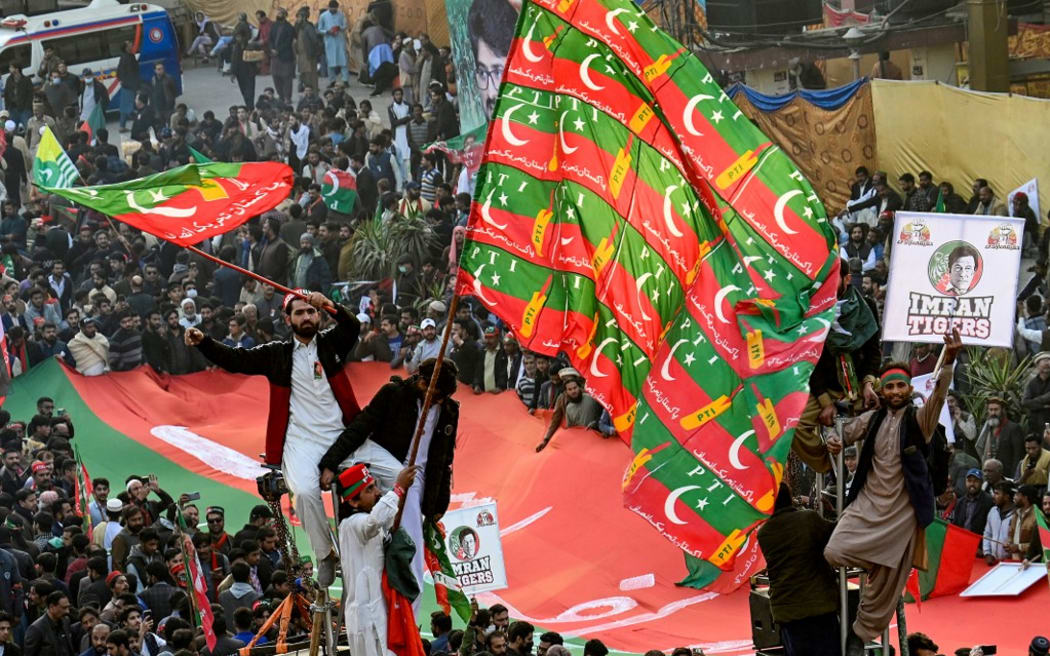 Supporters of former Pakistan's Prime Minister Imran Khan attend an anti-government rally in Rawalpindi on November 26, 2022. - Pakistan's former prime minister Imran Khan told tens of thousands of supporters on November 26 he would fight with his "last drop of blood" in a first public address since being shot in an assassination attempt earlier this month. (Photo by Aamir QURESHI / AFP)