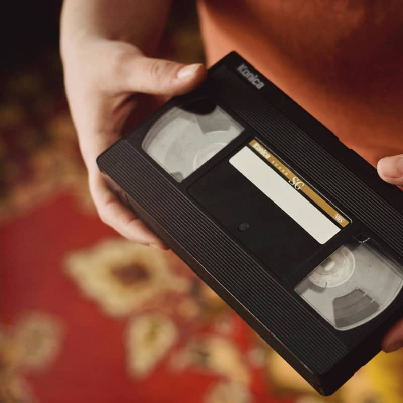 A person holds a VHS tape.