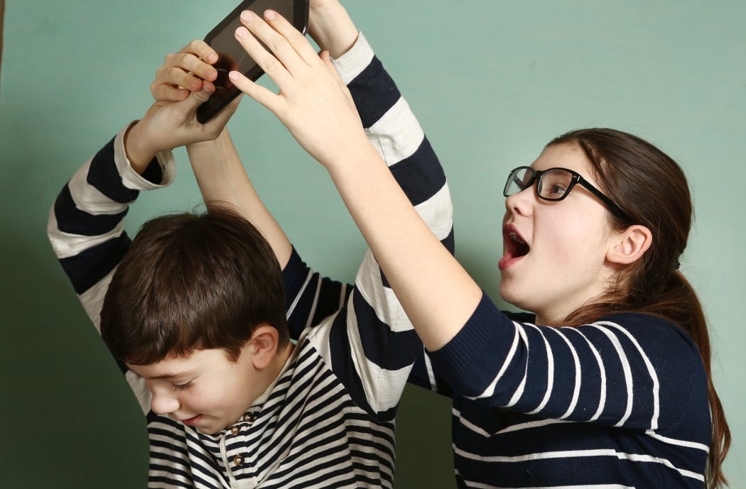 65478991 - teen siblings couple brother and sister in glasses fighting because of tablet try to take it for gaming